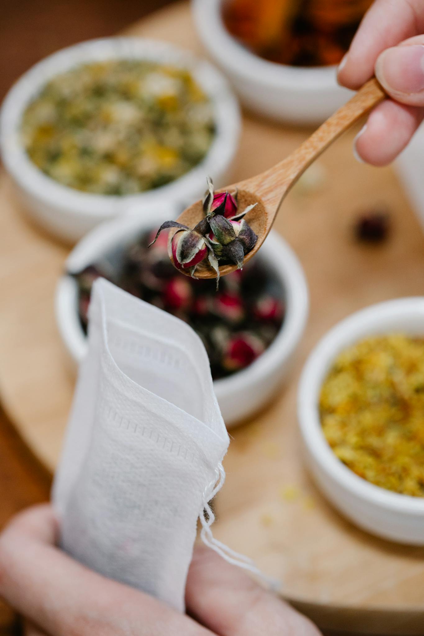 Close-up of herbal tea preparation using fresh spices and a wooden spoon.