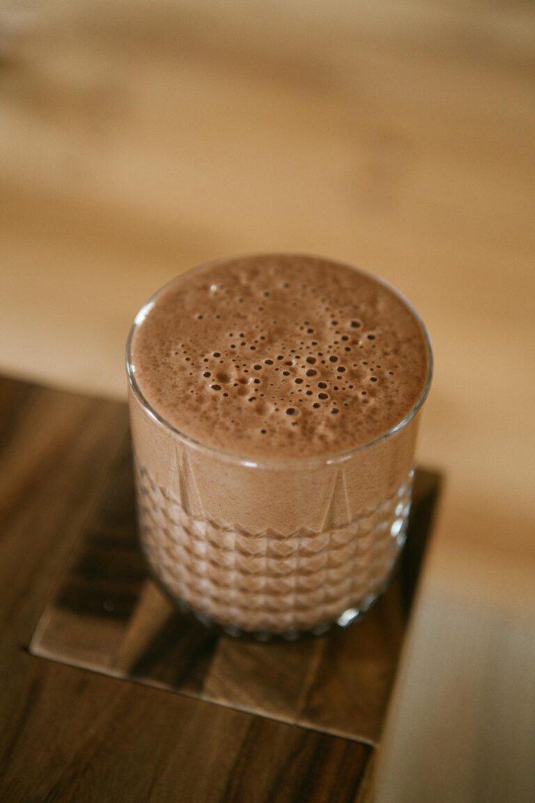 Frothy cacao beverage served in a stylish glass, highlighting its rich texture and aroma.